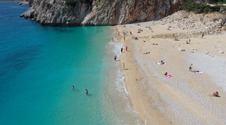 Antalya’nın ünlü Kaputaş Plajı’na gelen turistler güzel havada denize girdi